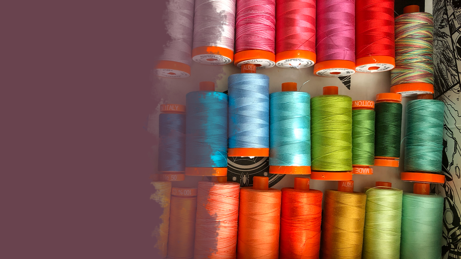 Rainbow spectrum of Aurifil thread on a white and black background