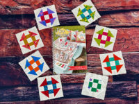 The four and a half inch churn dash blocks surround the Flea Market quilt along's pattern booklet.